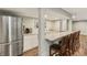 Finished basement bar area boasts a stainless steel refrigerator, countertop seating, and luxury vinyl plank flooring at 5441 Ellsworth Dr, Plainfield, IN 46168