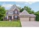Charming two-story brick home boasting a three-car garage, well-manicured lawn and inviting curb appeal at 5441 Ellsworth Dr, Plainfield, IN 46168