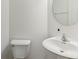 Clean and simple powder room featuring a pedestal sink, toilet, and neutral wall color at 5441 Ellsworth Dr, Plainfield, IN 46168