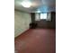 Basement space featuring wallpaper, dark wood paneling, carpet, and a small table setup at 5807 Sunwood Dr, Indianapolis, IN 46224