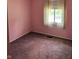 Pink bedroom featuring a window, carpet, and neutral trim at 5807 Sunwood Dr, Indianapolis, IN 46224