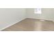 Bright, empty bedroom features wood-look flooring and a sunny window at 7151 Stetson Dr, Whitestown, IN 46052
