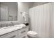 Bright bathroom featuring a marble vanity countertop, a toilet, and a shower with a white curtain at 729 Greenford N Trl, Carmel, IN 46032