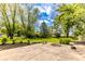 Spacious backyard featuring a patio area with a fire pit and mature trees at 7405 N Janna Dr, Muncie, IN 47303