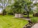 The backyard features a storage shed, mature trees and green grass at 7405 N Janna Dr, Muncie, IN 47303