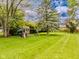 Green backyard featuring a play set and mature trees at 7405 N Janna Dr, Muncie, IN 47303
