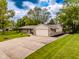 Charming single-story home featuring stone accents, a two-car garage, and a long driveway with lush landscaping at 7405 N Janna Dr, Muncie, IN 47303