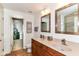 Bathroom with double sinks, bronze fixtures, vanity, and decorative mirror at 7733 Chestnut Eagle Ct, Zionsville, IN 46077