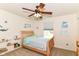 Bright bedroom with ceiling fan, window, and bookshelves at 7733 Chestnut Eagle Ct, Zionsville, IN 46077