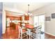 Open dining area with stainless steel appliances, cherry cabinets, and hardwood floors at 7733 Chestnut Eagle Ct, Zionsville, IN 46077