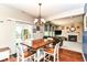 Bright dining area with wood table, white chairs, sliding glass doors to the backyard and living space at 7733 Chestnut Eagle Ct, Zionsville, IN 46077