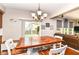 Bright dining area with wood table, white chairs, sliding glass doors to the backyard and living space at 7733 Chestnut Eagle Ct, Zionsville, IN 46077