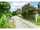 This property features a long gravel driveway leading to a cozy home, framed by lush green foliage at 7829 Rahke Rd, Indianapolis, IN 46217