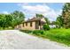 Cozy single-story home featuring a gravel driveway and lush green landscaping for a tranquil setting at 7829 Rahke Rd, Indianapolis, IN 46217