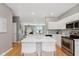 Open-concept kitchen with island, stainless steel appliances, white cabinets, and stylish backsplash at 8425 Codesa Way, Indianapolis, IN 46278