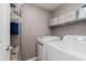 Functional laundry room with modern washer, dryer, and ample storage shelving at 8425 Codesa Way, Indianapolis, IN 46278