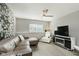 Cozy living room featuring a plush sectional sofa, fireplace, ceiling fan, and laminate flooring at 8425 Codesa Way, Indianapolis, IN 46278