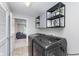Modern laundry room with front-load washer and dryer, overhead cabinets, and convenient shelving at 8556 N Deer Hill Dr, McCordsville, IN 46055