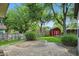 Green backyard with brick-lined garden area, red outbuilding, and tall trees at 8635 Bishops Ln, Indianapolis, IN 46217