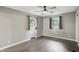 Neutral bedroom featuring two windows, gray walls, ceiling fan, and hardwood floors at 8635 Bishops Ln, Indianapolis, IN 46217