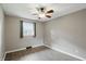 Cozy bedroom featuring wood-look floors, ceiling fan, soft neutral walls, and a bright window at 8635 Bishops Ln, Indianapolis, IN 46217