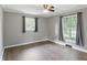 Bedroom with wood floors has a ceiling fan and two windows with dark curtains at 8635 Bishops Ln, Indianapolis, IN 46217