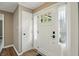 Inviting foyer featuring a white front door with glass panes, wood-look floors, and access to a closet at 8635 Bishops Ln, Indianapolis, IN 46217