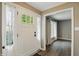 Bright foyer with white door, sidelights, wood floors and a view into the neutral-toned living room at 8635 Bishops Ln, Indianapolis, IN 46217