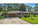 Charming home with manicured lawn, brick facade, dark roof, and a paved driveway leading to an attached garage at 8635 Bishops Ln, Indianapolis, IN 46217