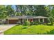 Charming brick home with a well-manicured lawn, a brown garage door, and a striking red front door at 8635 Bishops Ln, Indianapolis, IN 46217