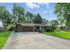 Single-story brick home featuring a long driveway and lush landscaping at 8635 Bishops Ln, Indianapolis, IN 46217
