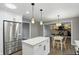 Kitchen with white cabinets, island, stainless steel refrigerator, and open view to the living area at 8635 Bishops Ln, Indianapolis, IN 46217