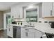 Kitchen area featuring a stainless steel sink and appliances surrounded by white cabinetry at 8635 Bishops Ln, Indianapolis, IN 46217