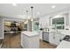 Open-concept kitchen, with white cabinets, stainless steel appliances, view of Gathering room with brick fireplace at 8635 Bishops Ln, Indianapolis, IN 46217