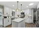 Bright kitchen with white cabinets, stainless steel appliances, island and modern pendant lighting at 8635 Bishops Ln, Indianapolis, IN 46217