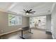Bright living room with large windows, ceiling fan, and an open layout into the kitchen at 8635 Bishops Ln, Indianapolis, IN 46217