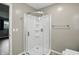 Shower with a frameless glass enclosure, modern fixtures and hardware, and pebble flooring at 8635 Bishops Ln, Indianapolis, IN 46217