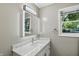 Light and airy vanity featuring a stone countertop, lighted mirror, and modern fixtures at 8635 Bishops Ln, Indianapolis, IN 46217