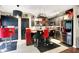 Modern kitchen with black cabinets, stainless steel appliances, and a red island with decorative chairs at 9605 Treyburn Green Way, Indianapolis, IN 46239