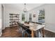 Bright dining room with wood table, wood floors, and shelving unit for storage and decor at 9840 N Anchor Bnd, McCordsville, IN 46055