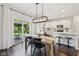 View of kitchen featuring a wooden table, white cabinets and trim, stainless appliances, and dark wood floors at 9840 N Anchor Bnd, McCordsville, IN 46055
