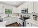 Bright kitchen with stainless steel appliances, quartz countertops, and white cabinetry at 9840 N Anchor Bnd, McCordsville, IN 46055