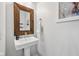 Stylish powder room features pedestal sink with rustic wood framed mirror and modern fixtures at 9840 N Anchor Bnd, McCordsville, IN 46055