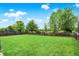 Spacious backyard with a well-maintained lawn, a sturdy wood fence, and mature shade trees at 10306 Mcclain Dr, Brownsburg, IN 46112