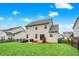 A charming two-story home with a large, well-maintained backyard, red steps, and a small patio, perfect for outdoor entertaining at 10306 Mcclain Dr, Brownsburg, IN 46112