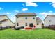 A charming two-story home with a large, well-maintained backyard, red steps, and a small patio, perfect for outdoor entertaining at 10306 Mcclain Dr, Brownsburg, IN 46112