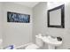 Elegant half bathroom featuring a vessel sink, modern fixtures, and stylish blue abstract artwork at 10306 Mcclain Dr, Brownsburg, IN 46112