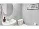 Elegant powder room featuring a sleek, oval mirror, modern faucet, and minimalist black and white art at 10306 Mcclain Dr, Brownsburg, IN 46112