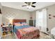 Well-lit bedroom with stylish silver-dot accent wall, ceiling fan, and window with light-filtering curtains at 10306 Mcclain Dr, Brownsburg, IN 46112