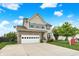 Inviting two-story home with a stone facade and attached garage, complemented by a green lawn and blue sky at 10306 Mcclain Dr, Brownsburg, IN 46112